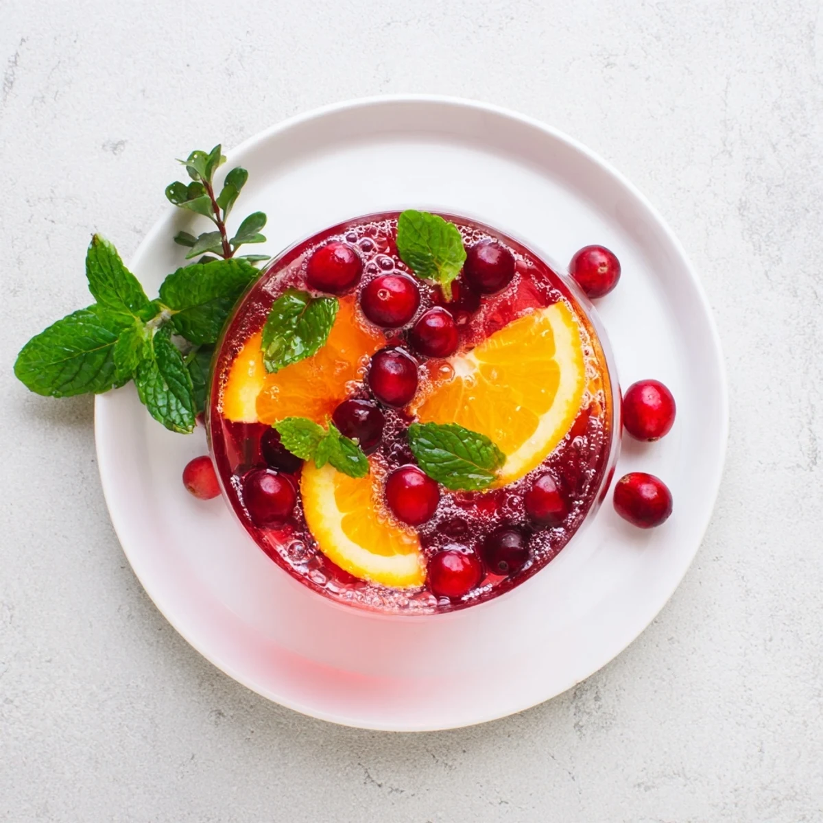 Refreshing Sparkling Cranberry Punch, garnished with orange slices and cranberries, ready to serve over ice.