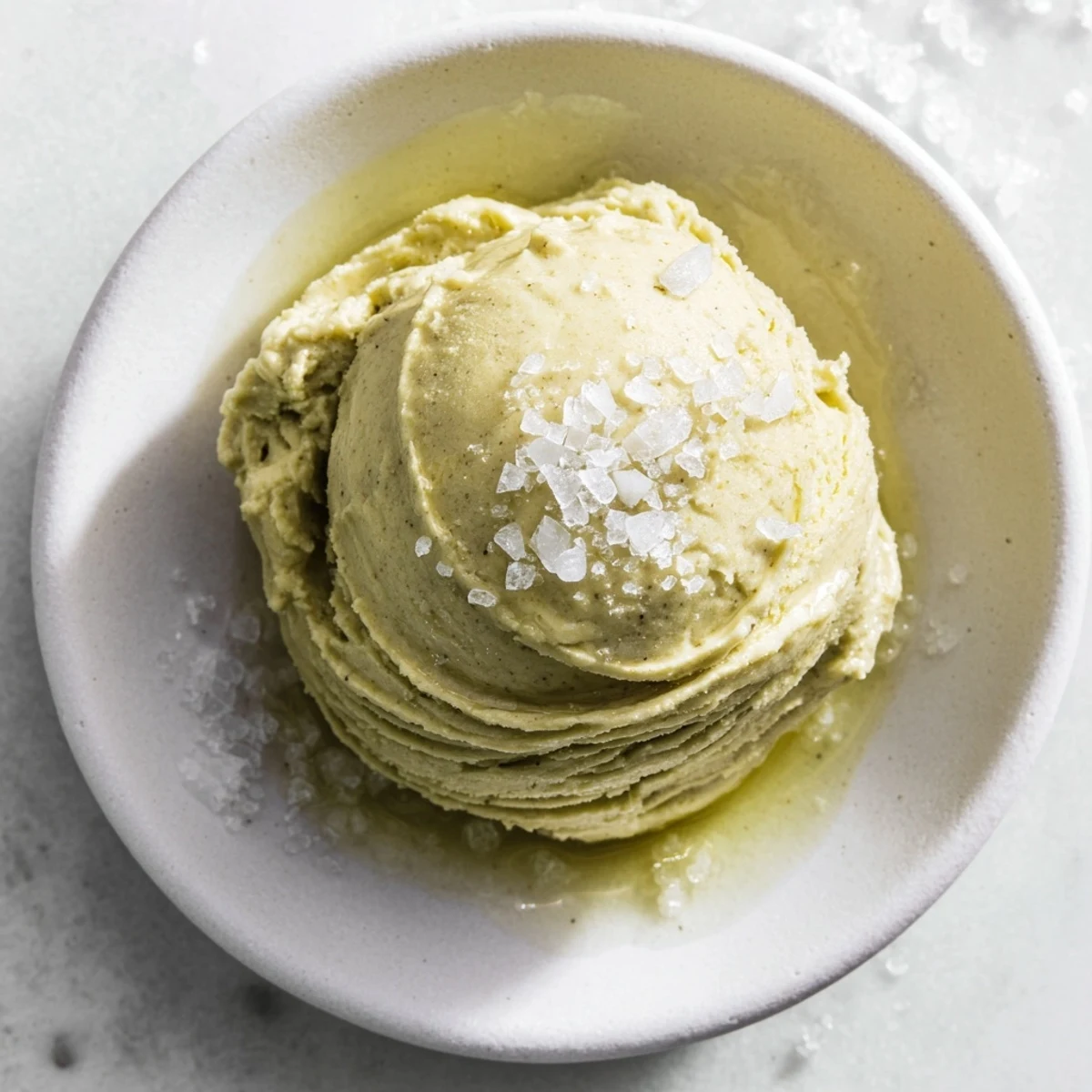 Silky Olive Oil Ice Cream, swirled with delicate olive oil, ready to be scooped and enjoyed.