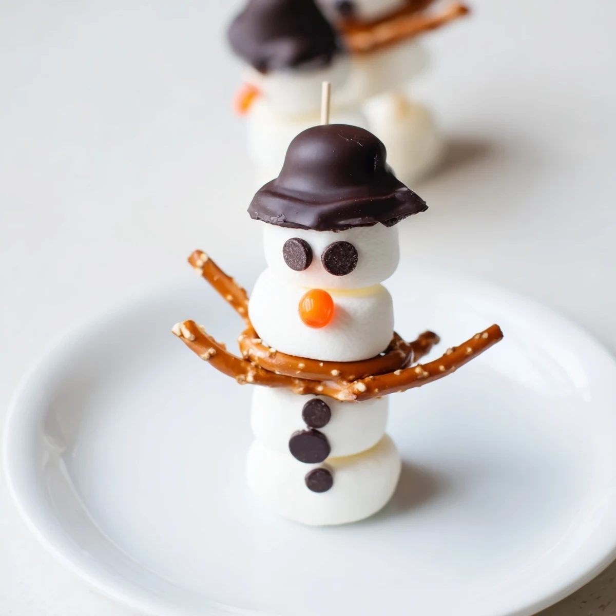 Adorable marshmallow snowman sticks, perfect for winter parties and featuring whimsical edible details.