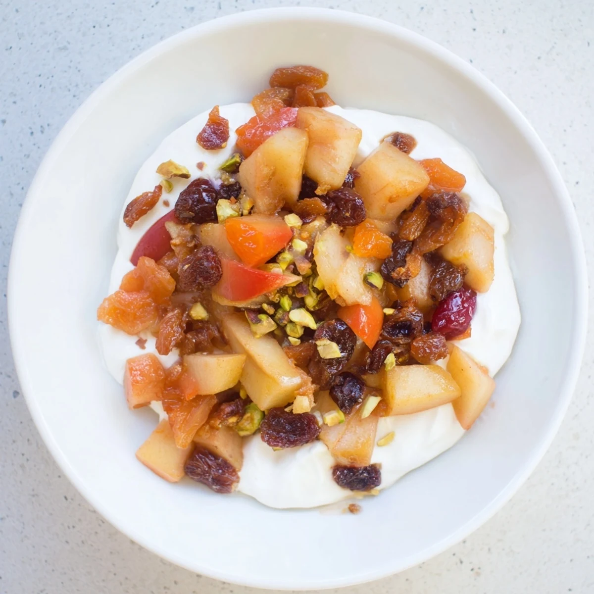 A close-up of winter fruit compote: apples, pears, apricots, delicious with yogurt and nuts.
