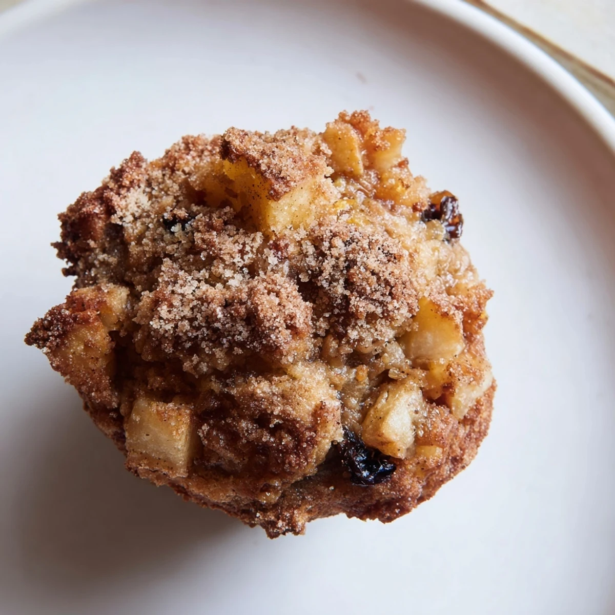 Golden, freshly baked Spiced Apple and Raisin Muffins, ready to eat, with a cinnamon-sugar topping.
