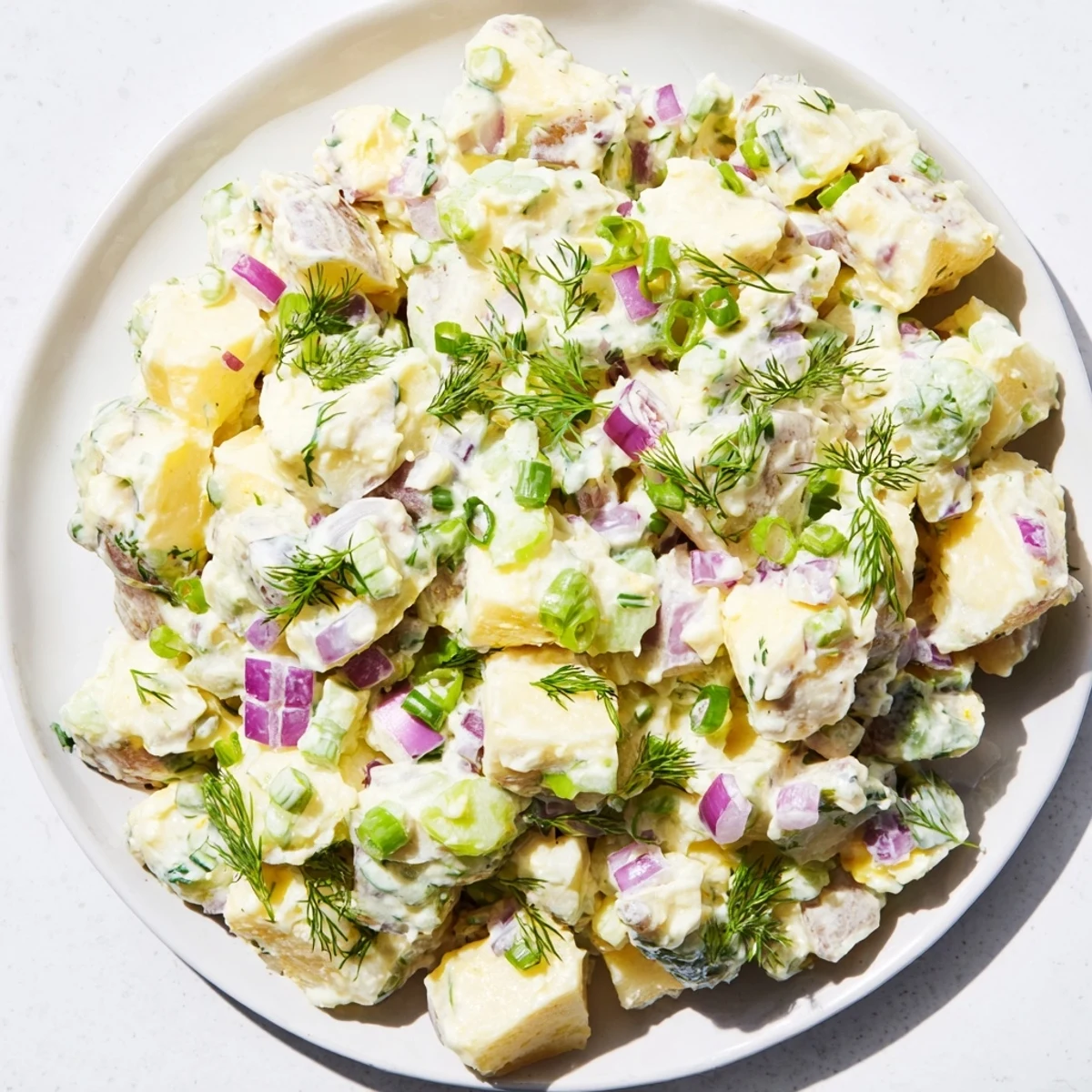 A bowl of chilled Creamy Potato Salad, perfect for summer barbecues, with visible chunks of potato.