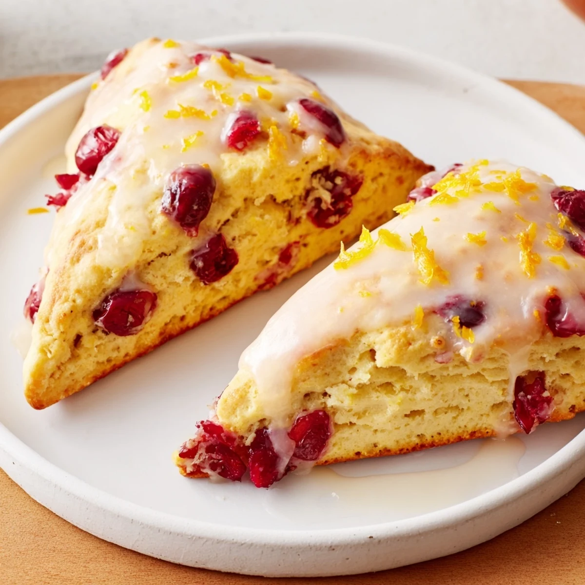 Warm cranberry orange scones with a sweet orange glaze, perfect for a cozy brunch spread.