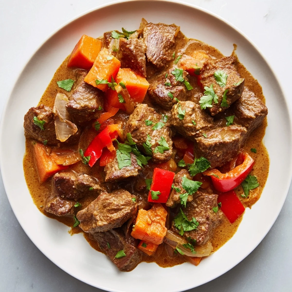 Tender slow cooker beef curry, served with fluffy white rice and fresh cilantro garnish.