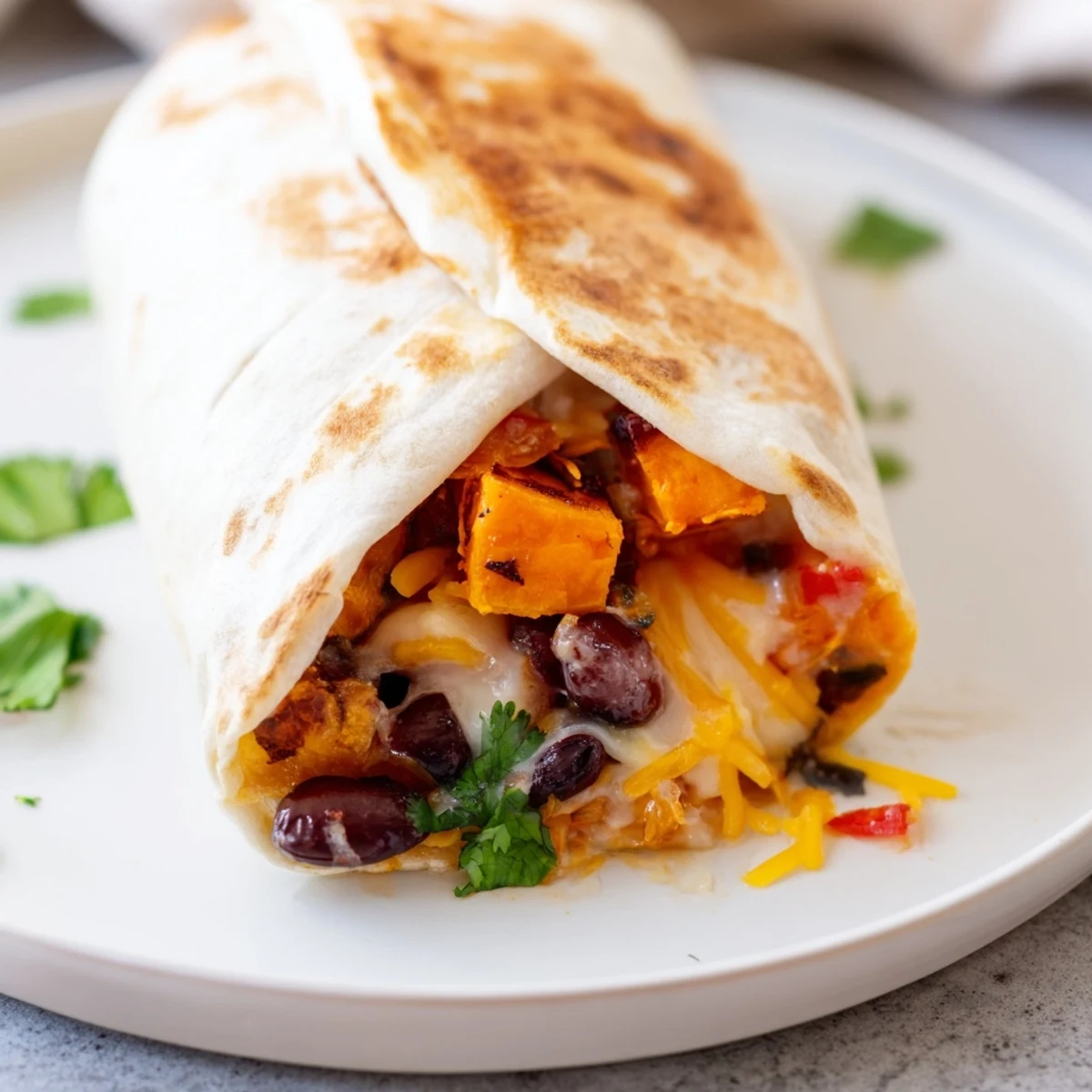 Oven-roasted sweet potatoes and seasoned black beans stuffed in a warm flour tortilla, topped with cheddar and fresh cilantro.