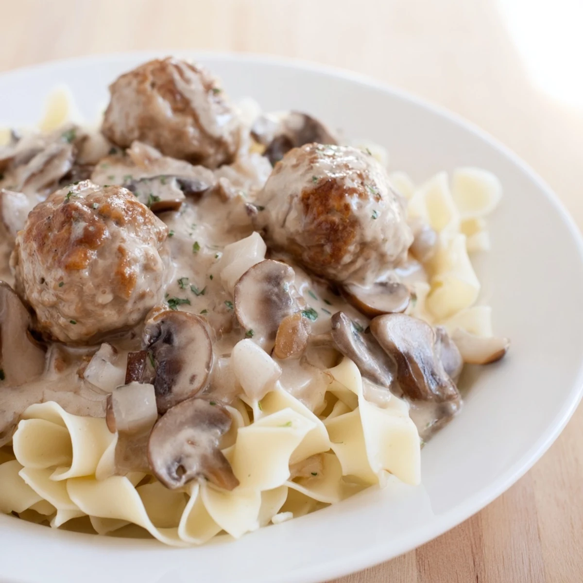 Golden brown turkey meatballs coated in creamy mushroom stroganoff, served over tender egg noodles and garnished with fresh parsley.