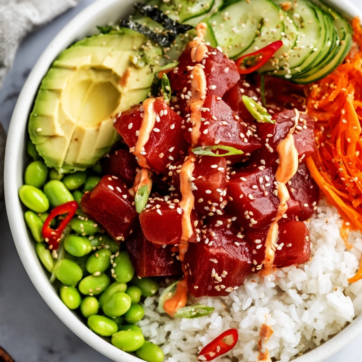 Fresh diced tuna marinated in a spicy sriracha and soy sauce mixture, served over sushi rice with creamy avocado slices.  