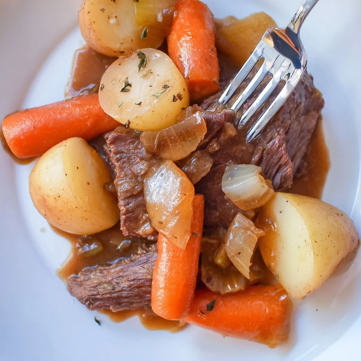 Golden-brown Irish Beef Pot Roast with carrots and potatoes in a rich gravy, served on a rustic platter.