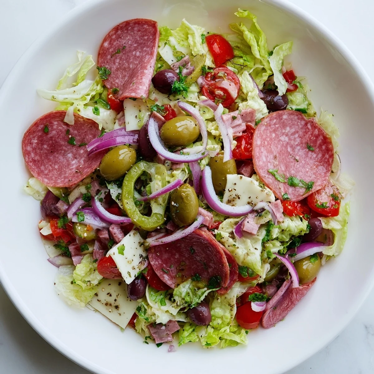 Colorful New Orleans Muffuletta Salad with olives, salami, and mozzarella tossed in a zesty Italian dressing.