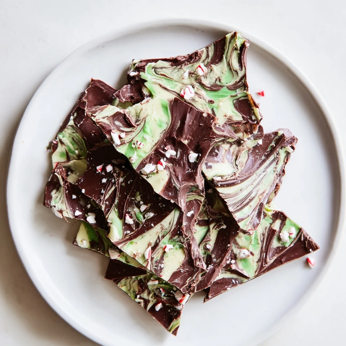 Shards of dark chocolate bark with a cool minty flavor and elegant white chocolate swirls, perfect for a festive holiday dessert platter.