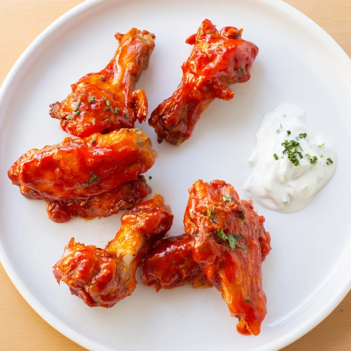 Spicy Chicken Wings with Ranch Dressing tossed in a fiery hot sauce glaze, ready for dipping.