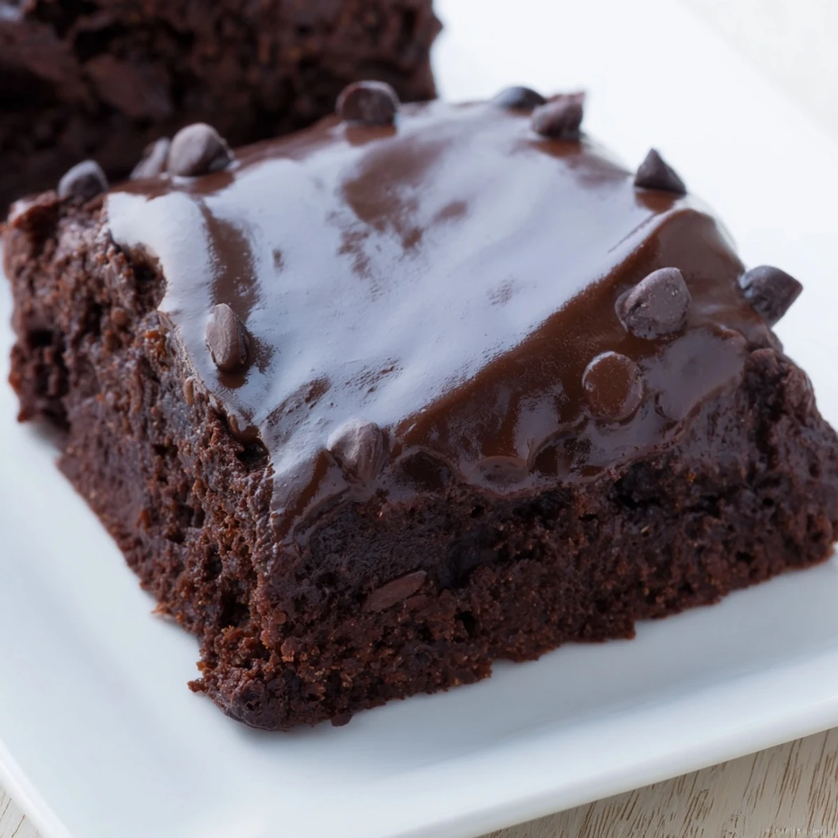 Golden-brown Mint Chocolate Chip Brownies with ganache are served on a rustic wooden board, sprinkled with minty sugar crystals for extra flavor.
