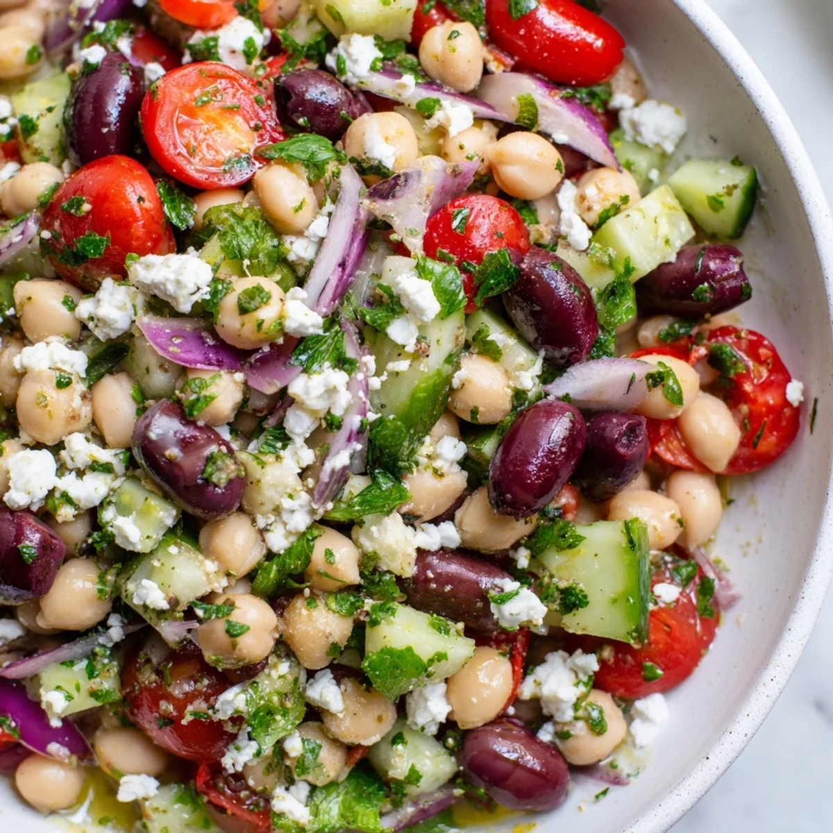 A serving of the Mediterranean Dense Bean Salad with crumbled feta cheese, ready for a healthy lunch.