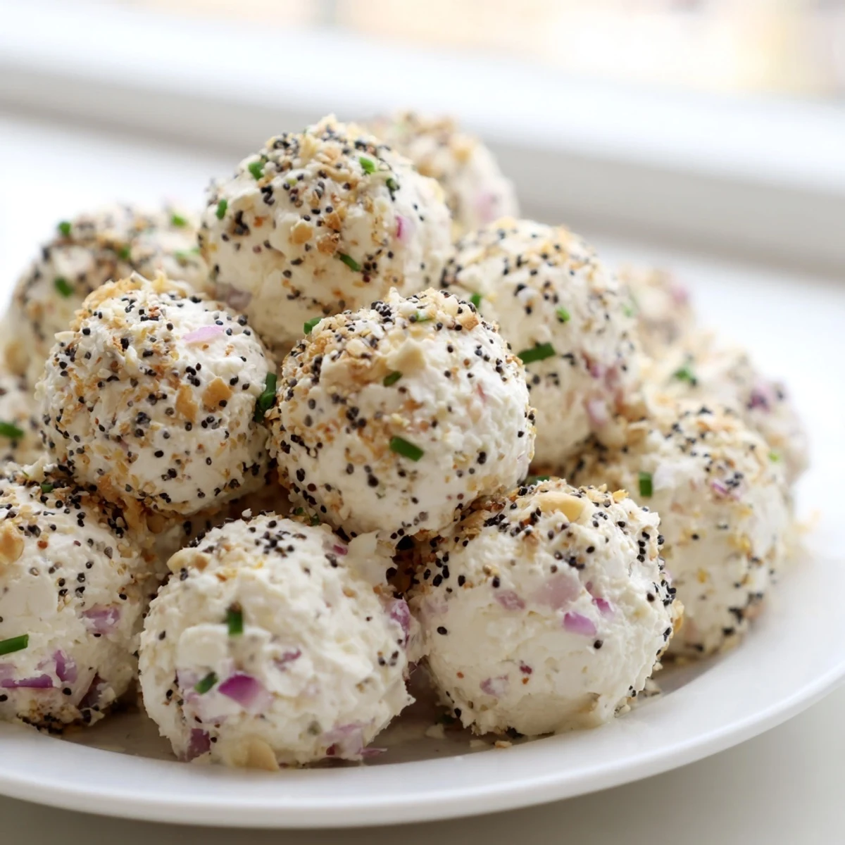 A close-up of Everything Bagel Cottage Cheese Bites shows creamy texture and savory seasoning on a rustic serving board.