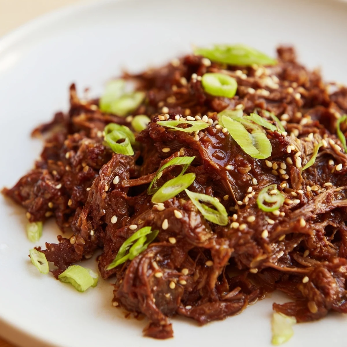 Slow cooker Korean beef, tender and glistening in a rich brown sauce, served with fluffy rice and sesame seeds.