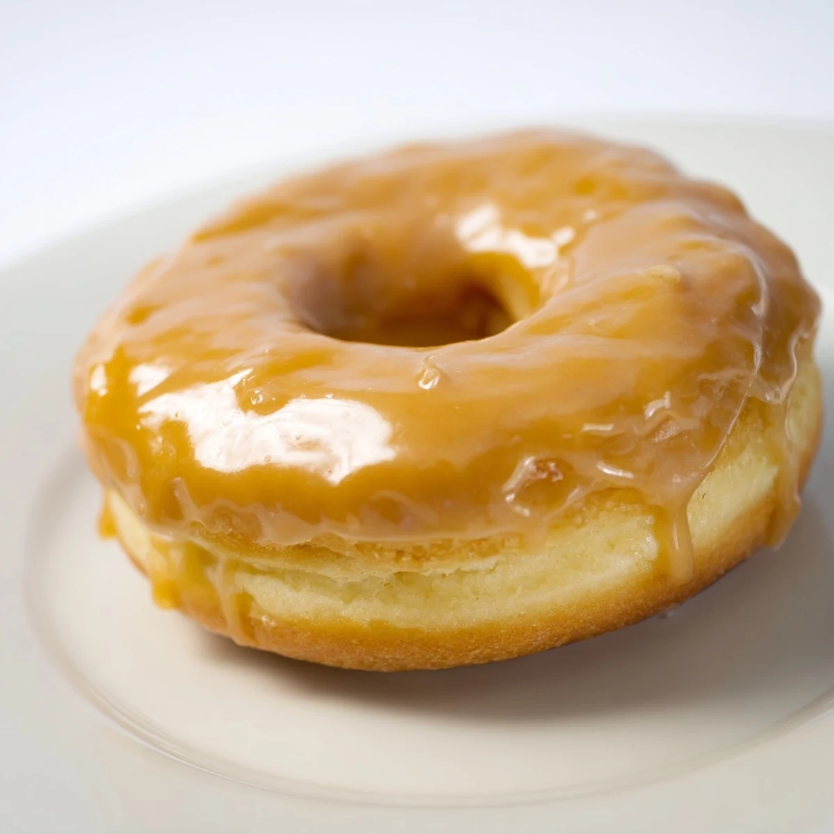 A close-up of Maple Donut Bars with a glossy, crackled maple glaze on a rustic wooden board.