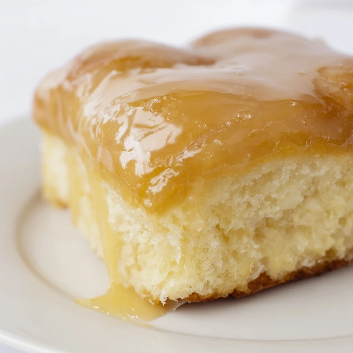 Maple Donut Bars arranged on a wire rack with drips of sweet glaze falling onto parchment paper below.