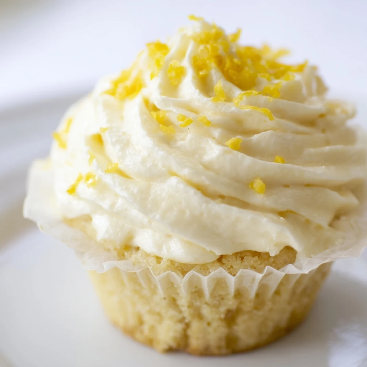 A close-up view of a Limoncello Cupcake showing a moist crumb and a drizzle of sweet syrup.