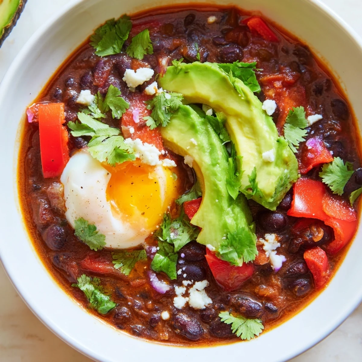 Hearty Mexican Braised Beans With Soft Boiled Egg served beside warm corn tortillas, perfect for a comforting vegetarian dinner.