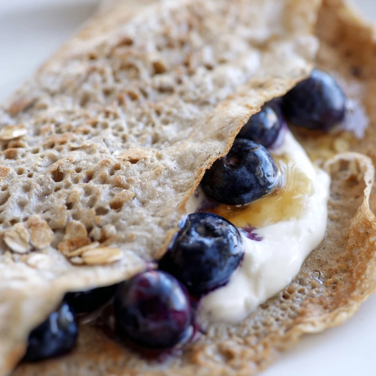 Light tender healthy oatmeal crepes filled with Greek yogurt and sliced bananas for breakfast