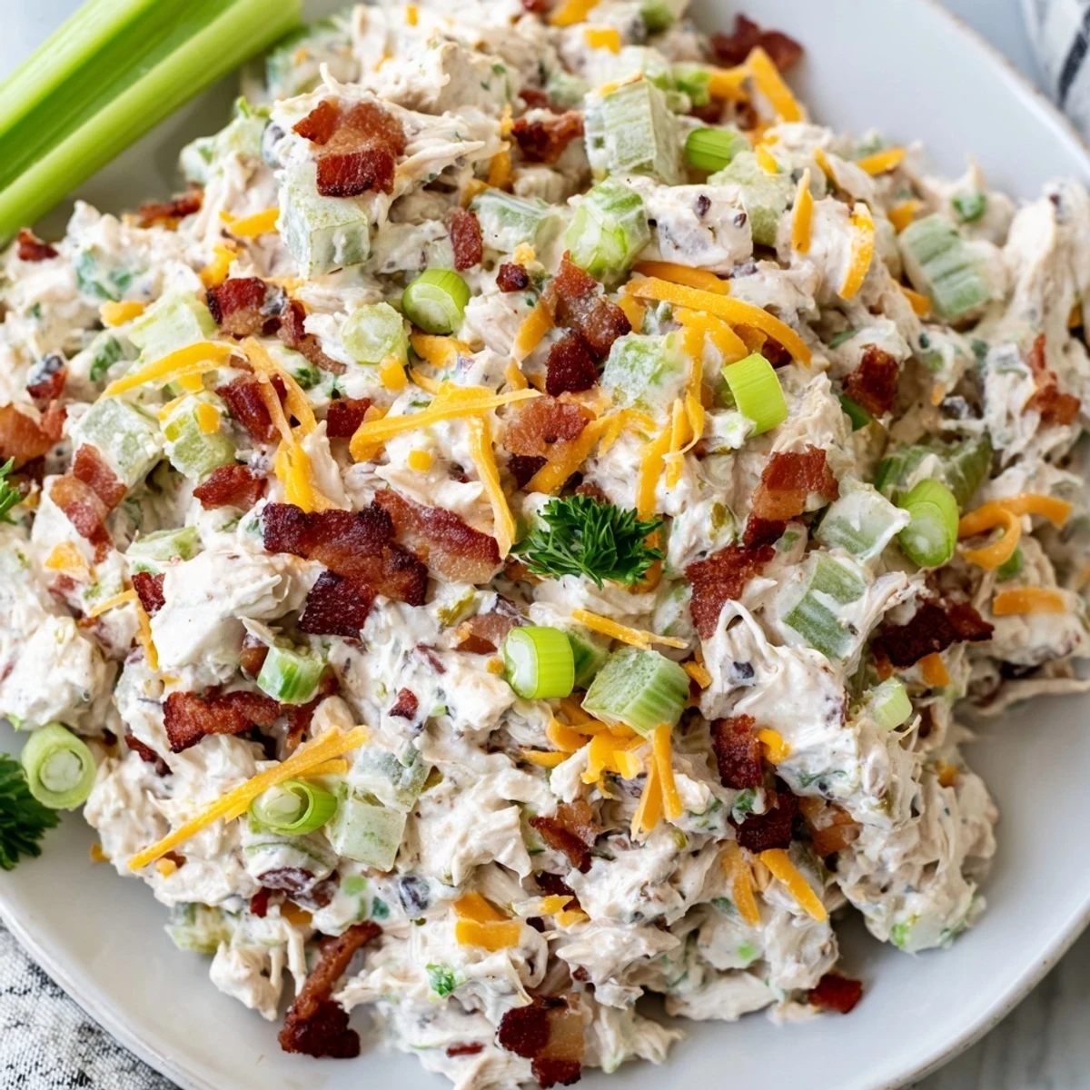 Spoonful of zesty cottage cheese chicken salad with diced jalapenos, cheddar cheese, and green onions