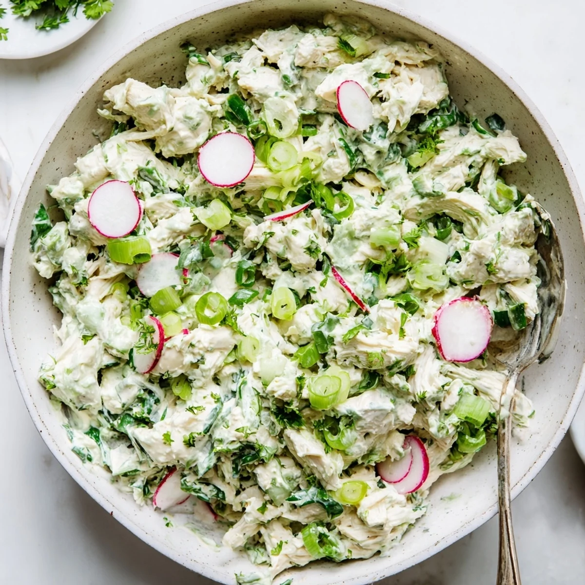Creamy Green Goddess Chicken Salad Dip served in a white bowl with fresh herb garnish and crackers