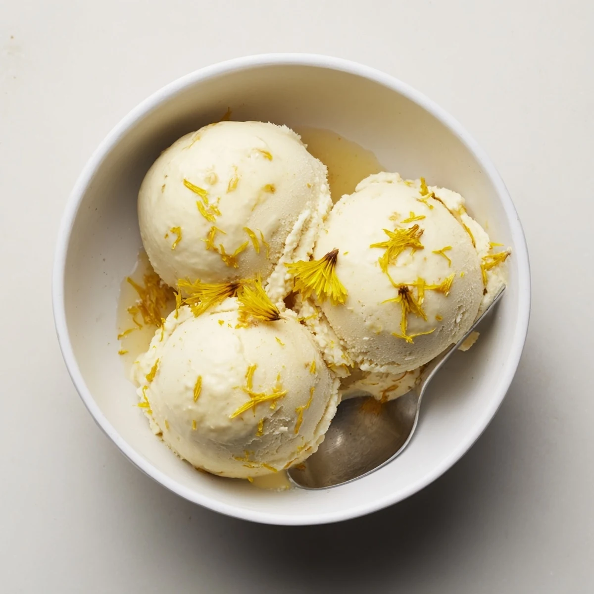 Rich floral dandelion honey ice cream drizzled with extra honey on a rustic plate.