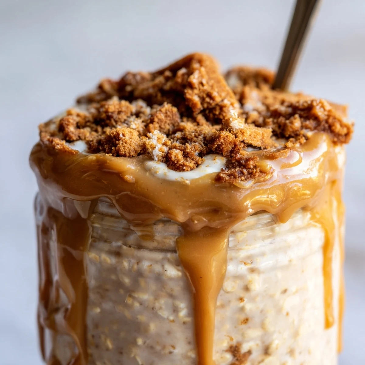 Biscoff overnight oats swirled with speculoos spread and finished with crunchy cookie pieces for breakfast