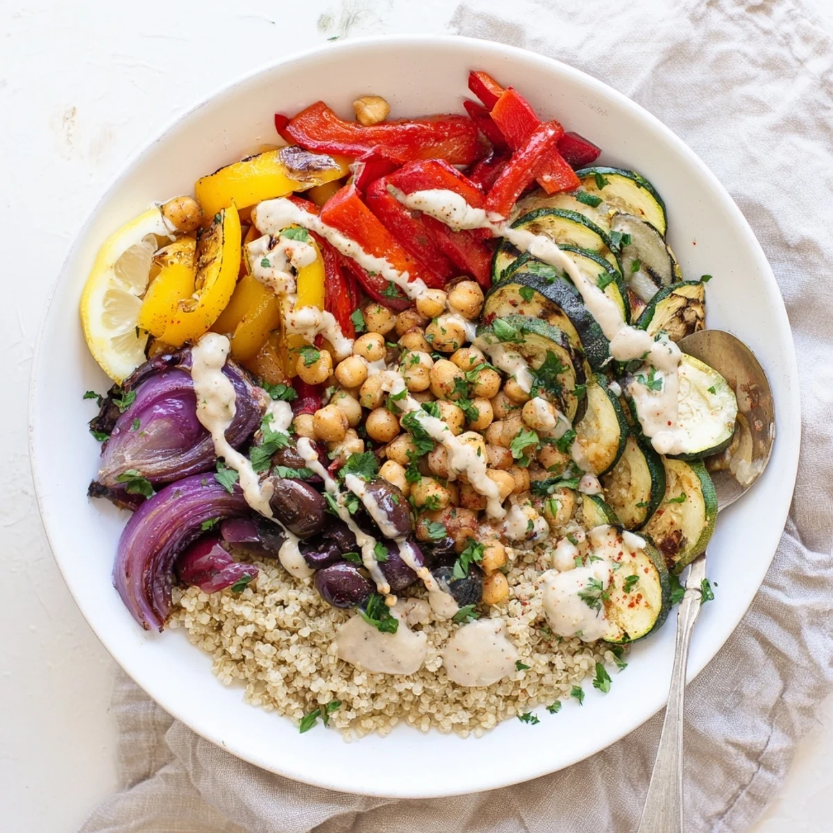 Golden roasted zucchini, eggplant, and chickpeas in a vegan Mediterranean roasted vegetables bowl drizzled with creamy tahini dressing.