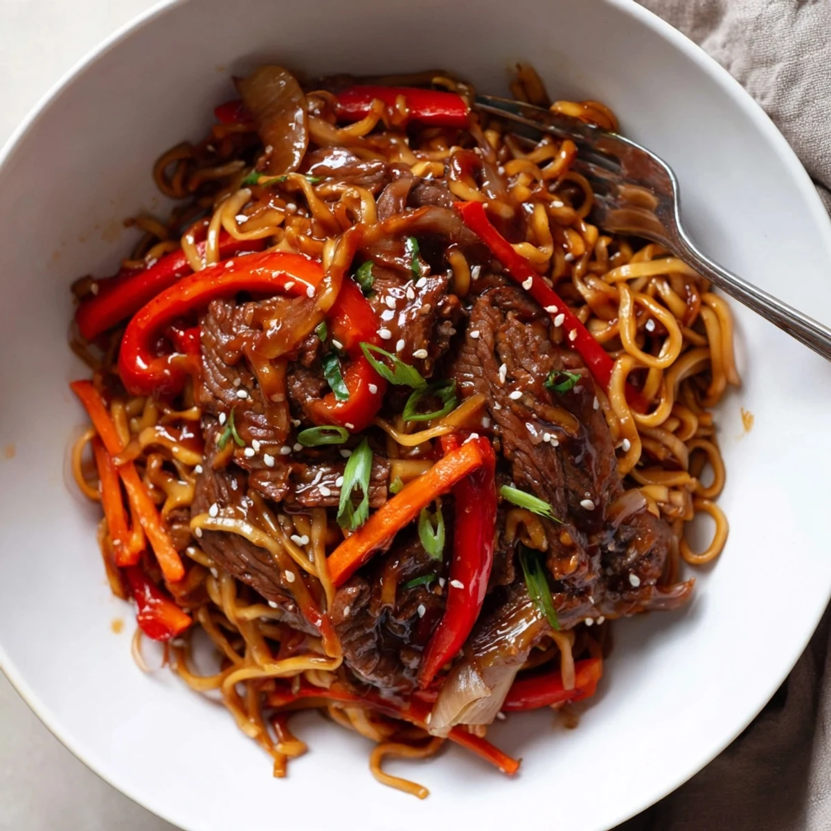 Wok-tossed Sticky Beef Noodles served immediately with toasted sesame seeds and herbs