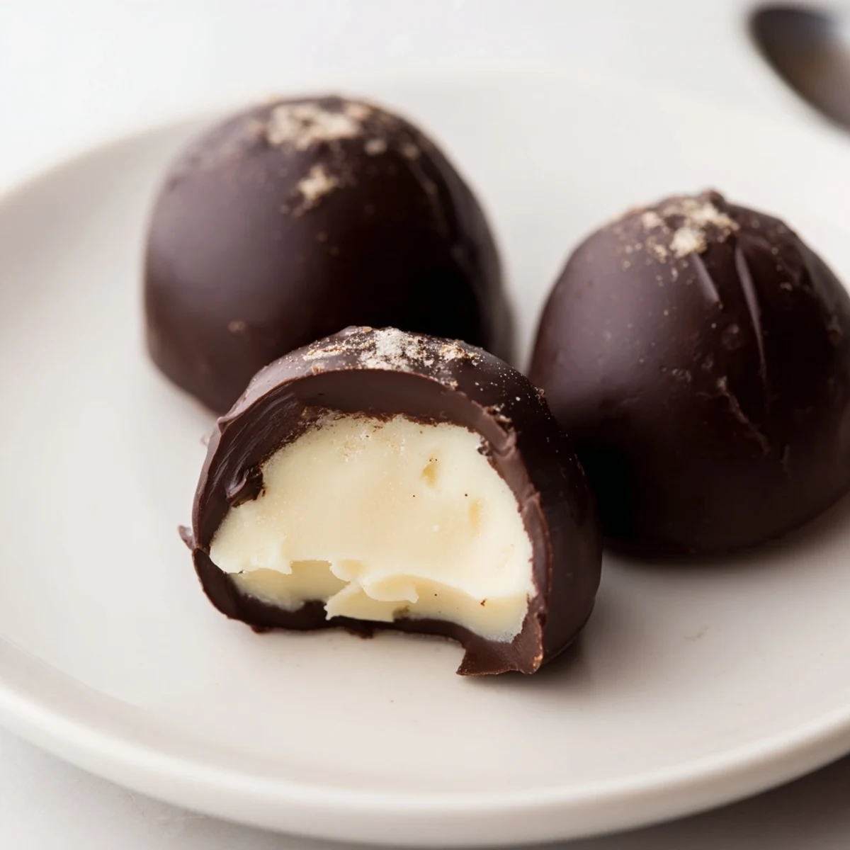 Sliced in half, Dark Chocolate Eggnog Truffles reveal velvety eggnog ganache