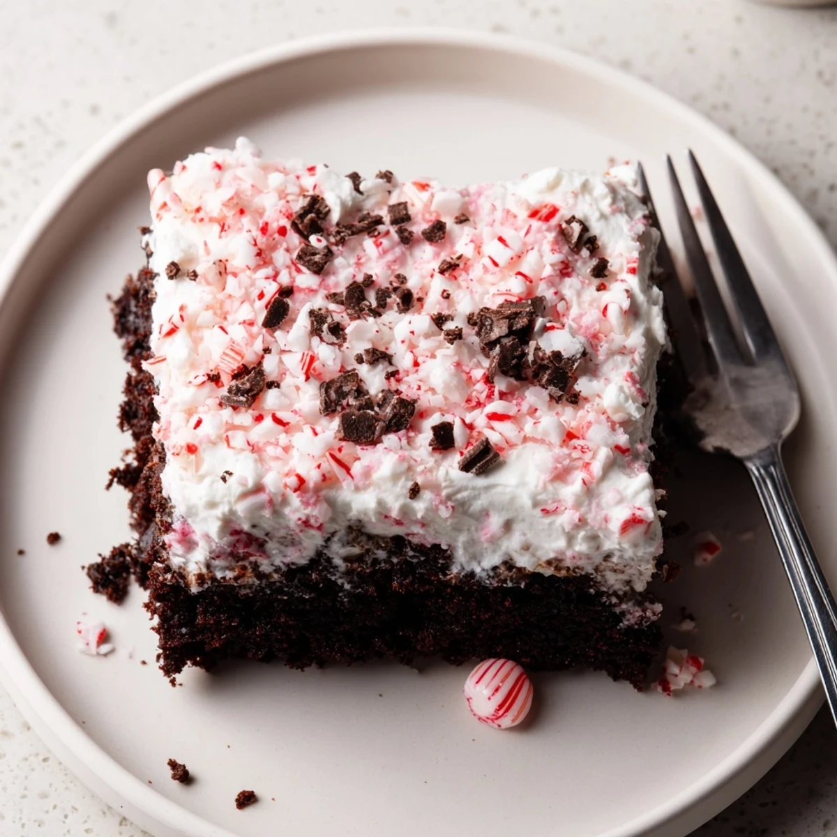 Festive Peppermint Poke Cake on platter, minty chocolate slices ready to serve