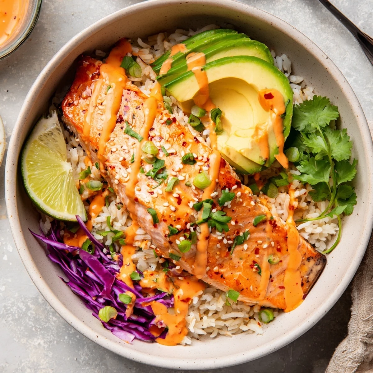 Bang Bang Salmon Bowls with roasted flaky salmon, avocado, rice, creamy sauce