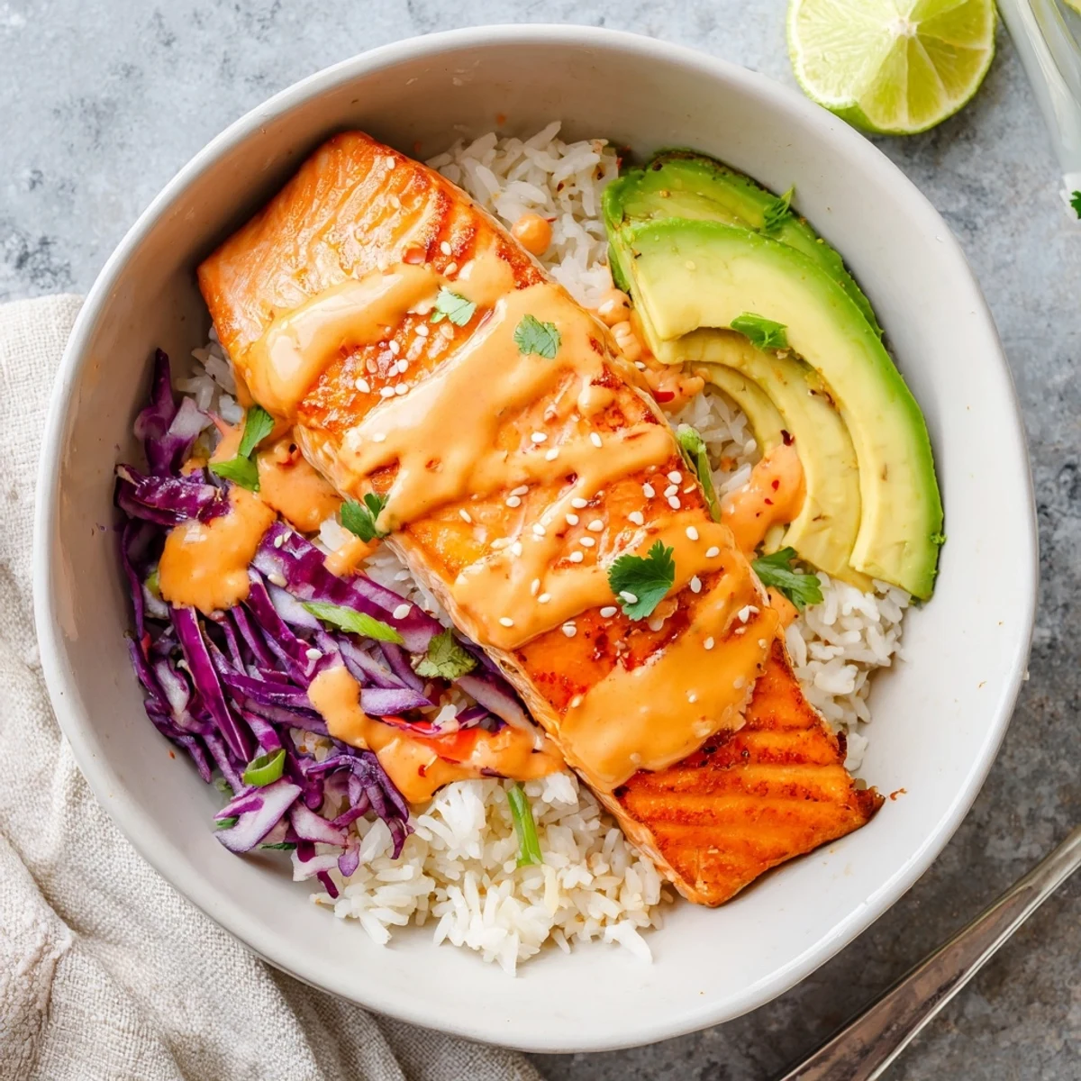 Weeknight Bang Bang Salmon Bowls served over warm jasmine rice, crisp cabbage