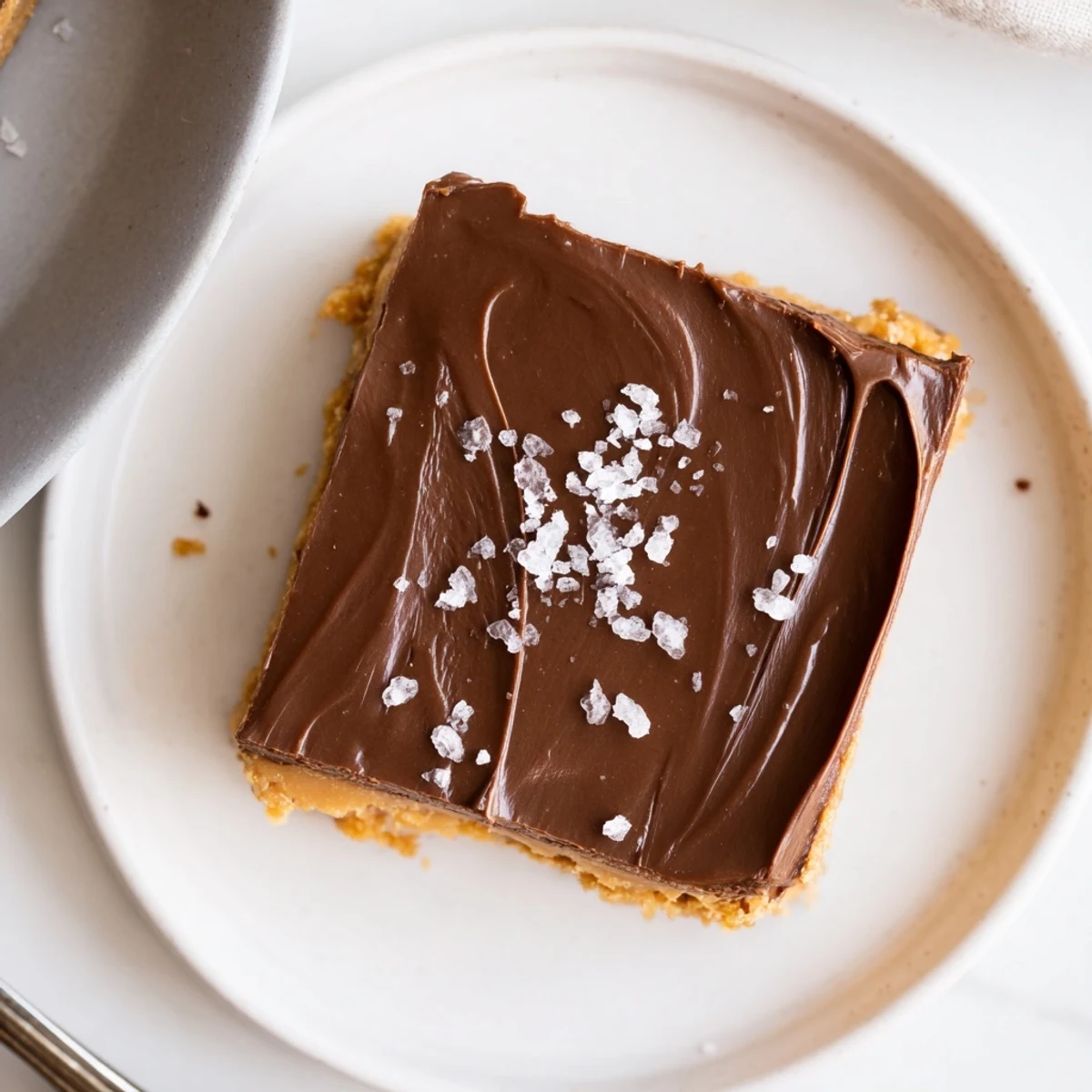 Chunky salt-sprinkled No Bake Peanut Butter Bars served on parchment, ready to enjoy