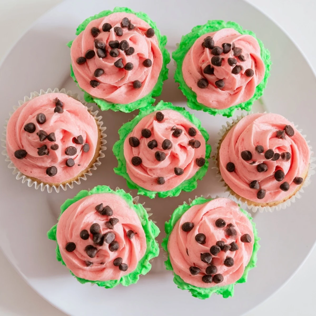 Moist vanilla watermelon cupcakes topped with pink watermelon buttercream frosting and chocolate chip seeds