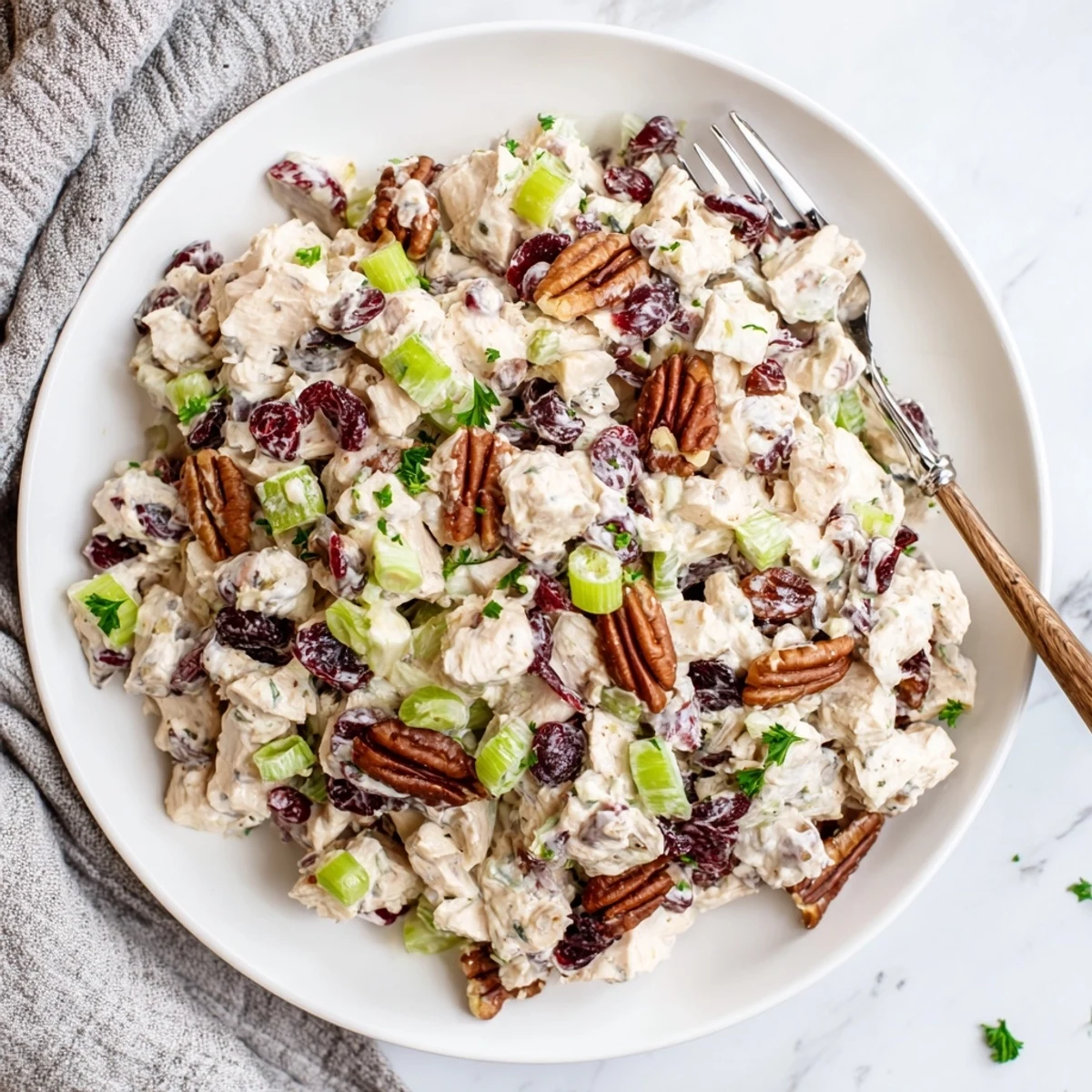 Creamy cranberry pecan chicken salad served in a white bowl with toasted pecans and bright red cranberries visible throughout
