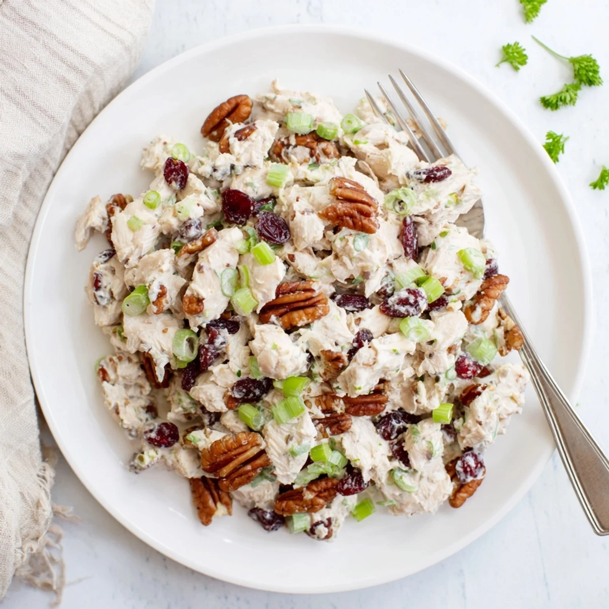 Fresh cranberry pecan chicken salad piled on a croissant with green onions and celery adding crunch