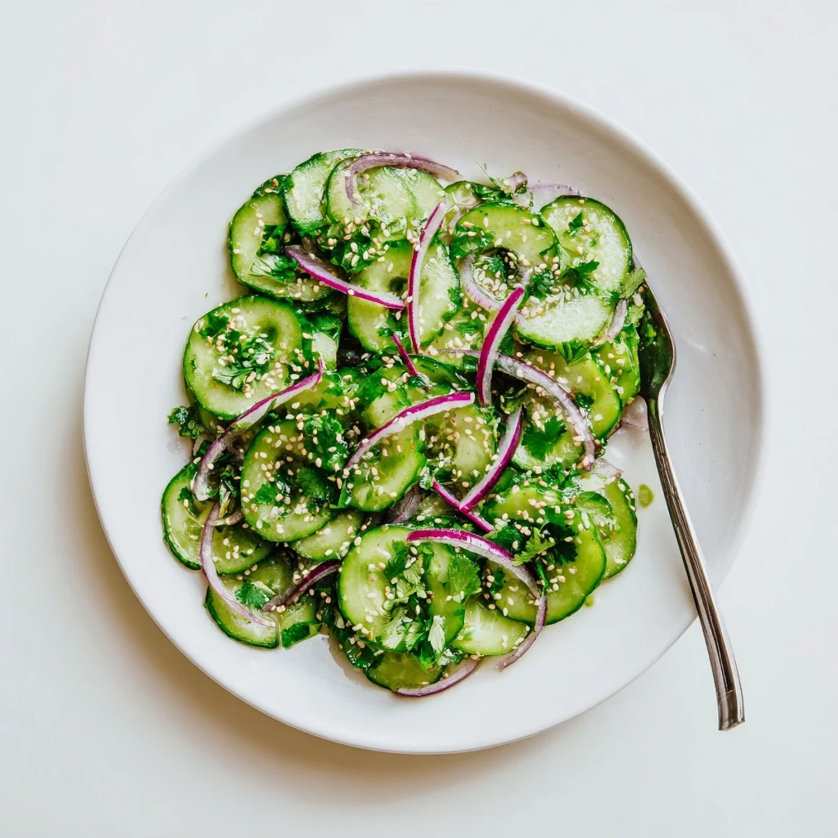Chilled honey lime cucumber salad with thinly sliced vegetables coated in a light honey lime vinaigrette and sesame garnish