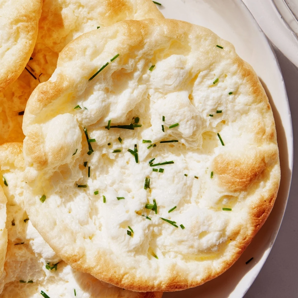 Stack of No Flour Cottage Cheese Cloud Bread topped with chives, breakfast-ready
