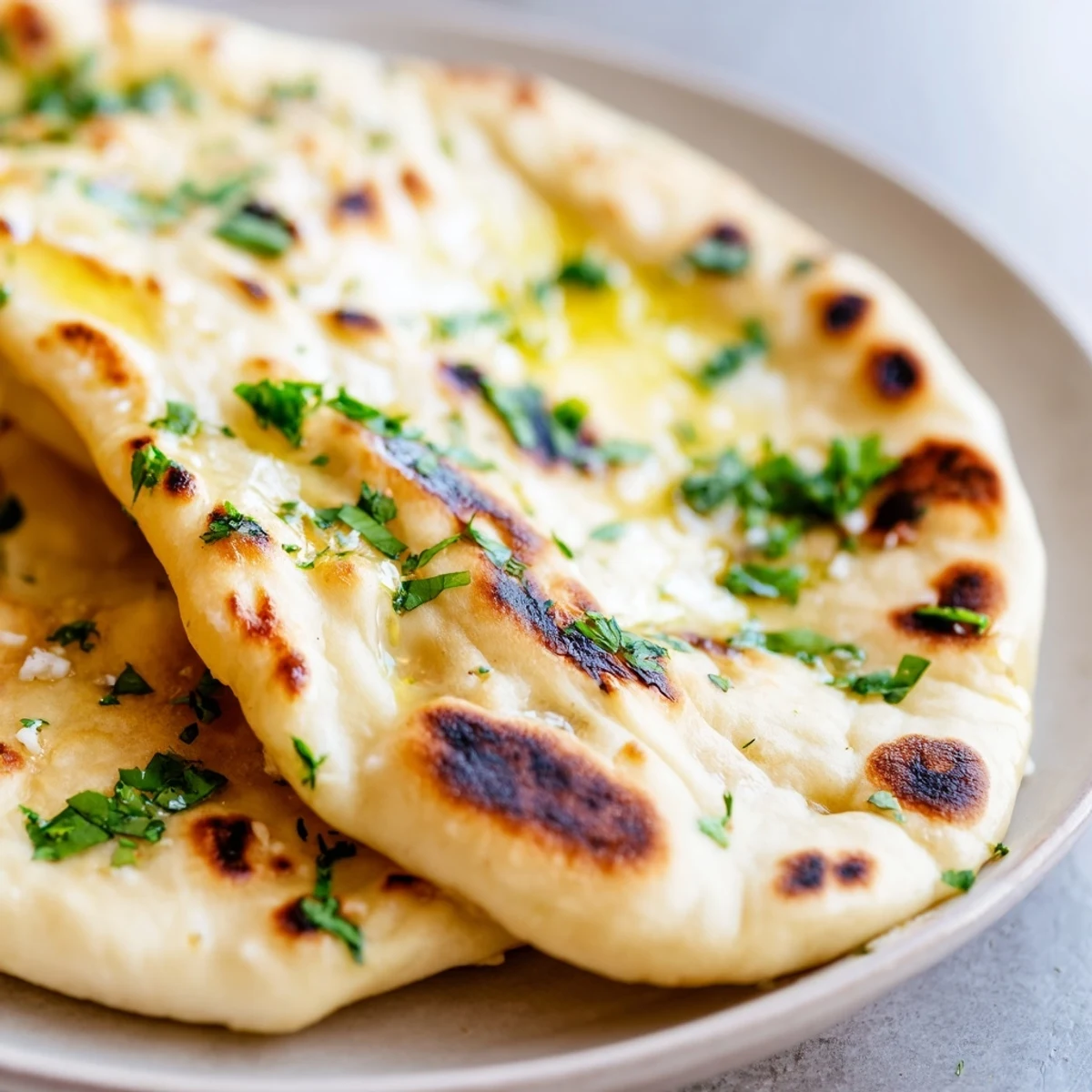 Pillowy Indian-inspired sourdough discard naan with golden charred spots perfect for scooping curries