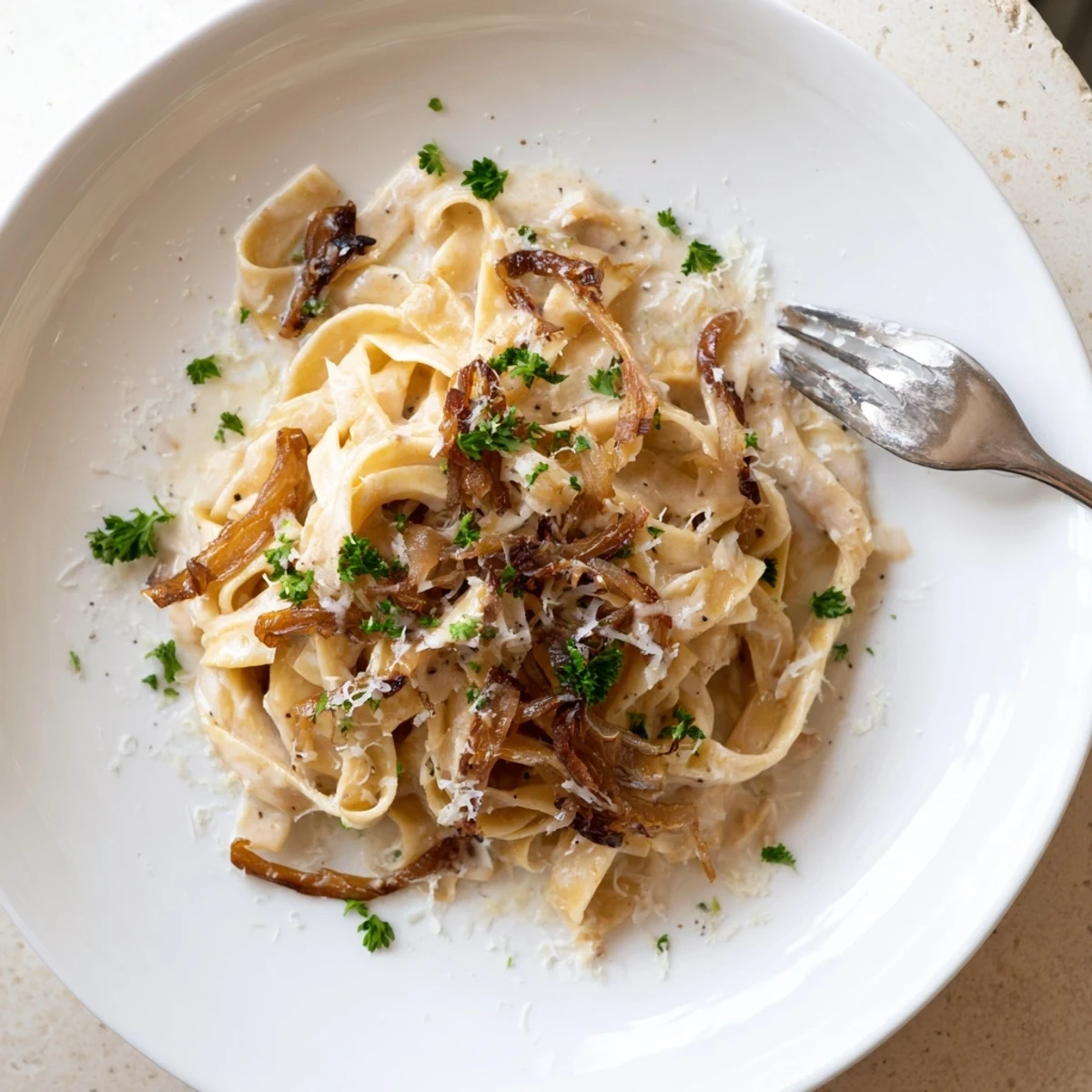 Golden brown caramelized onion cream pasta coated in a velvety white parmesan sauce