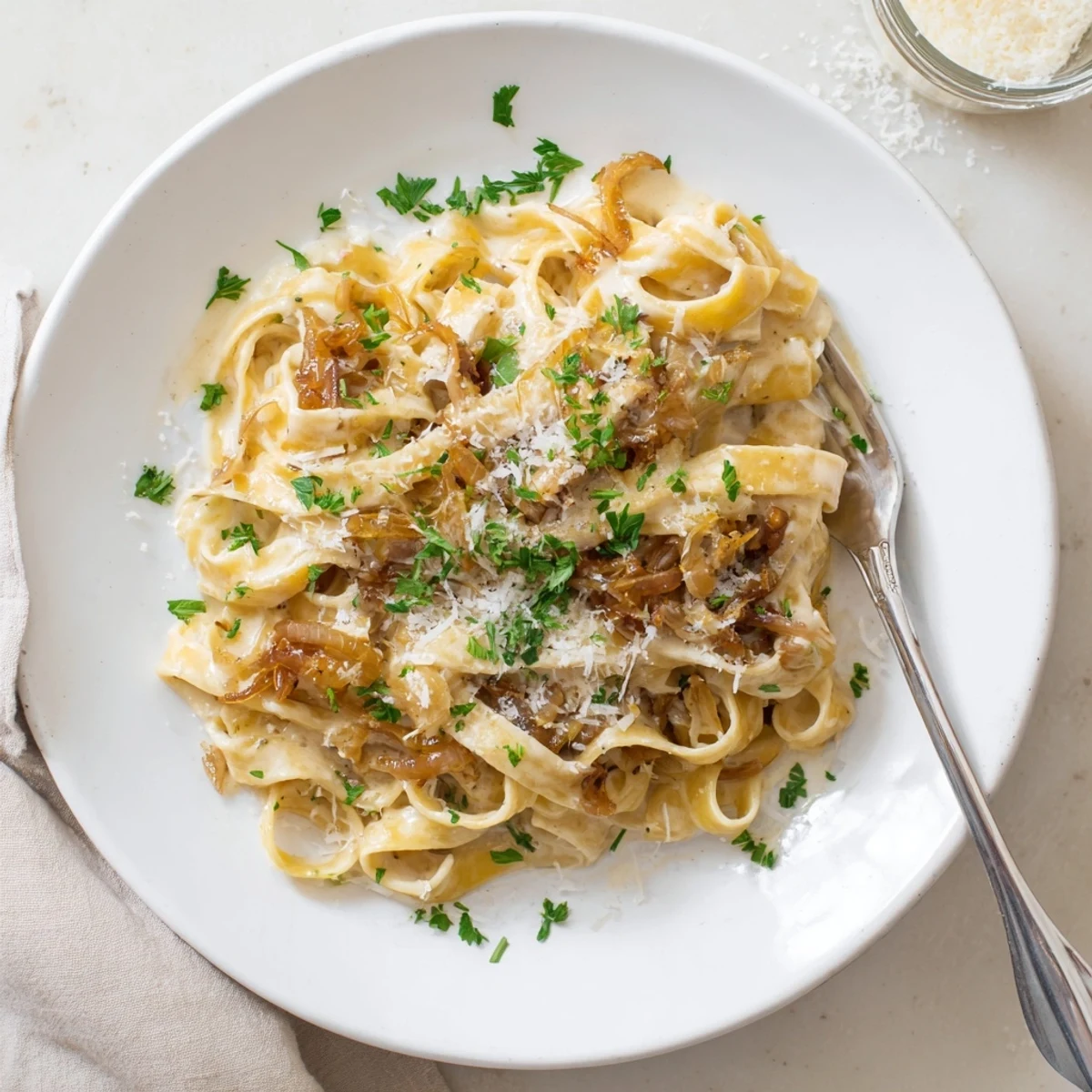 Rich caramelized onion cream pasta recipe featuring silky fettuccine noodles in luxurious sauce