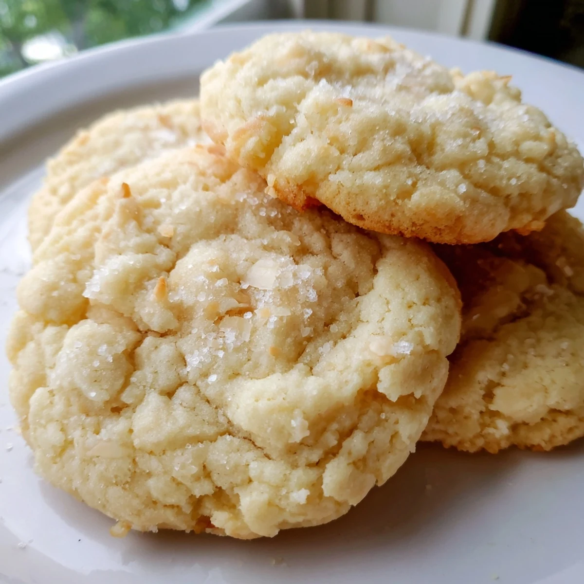 Golden soft and buttery coconut cookies fresh from the oven on parchment paper.