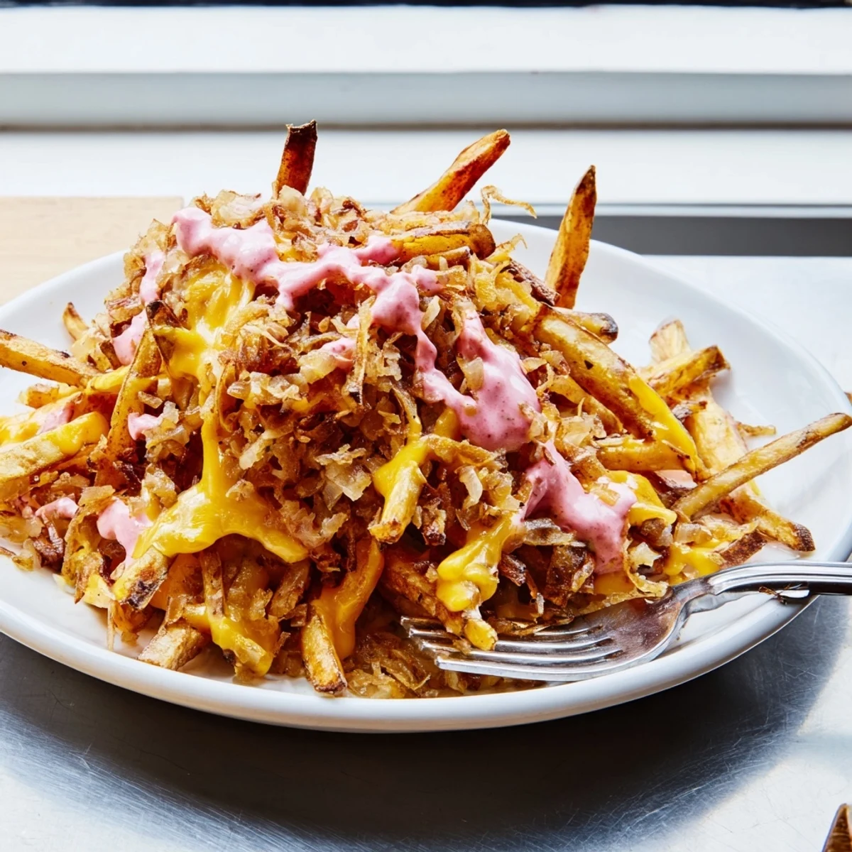 Crispy golden Animal Style Fries loaded with melted cheese and caramelized onions in a rustic dish