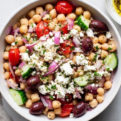 Colorful Mediterranean Chickpea Salad with Feta and Olives tossed in a rustic ceramic bowl, ready to serve for a light lunch.