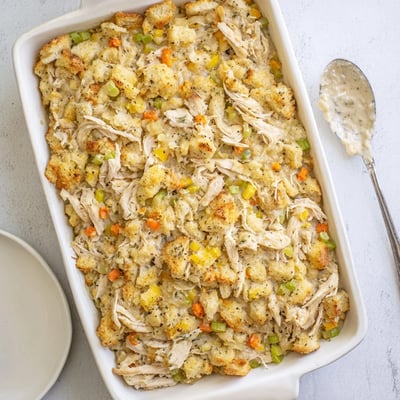 Warm Dollys Chicken Stuffing Casserole beside a fresh green salad on a rustic family table.